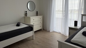 Une chambre à coucher au style minimaliste, avec un lit, une commode et une table de chevet.