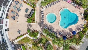 An aerial view of a hotel with a large outdoor swimming pool, sun loungers, and a landscaped garden area. - Two bedroom condo on Siesta Key with 2 pools, marina, tennis courts & more! (Siesta Key)