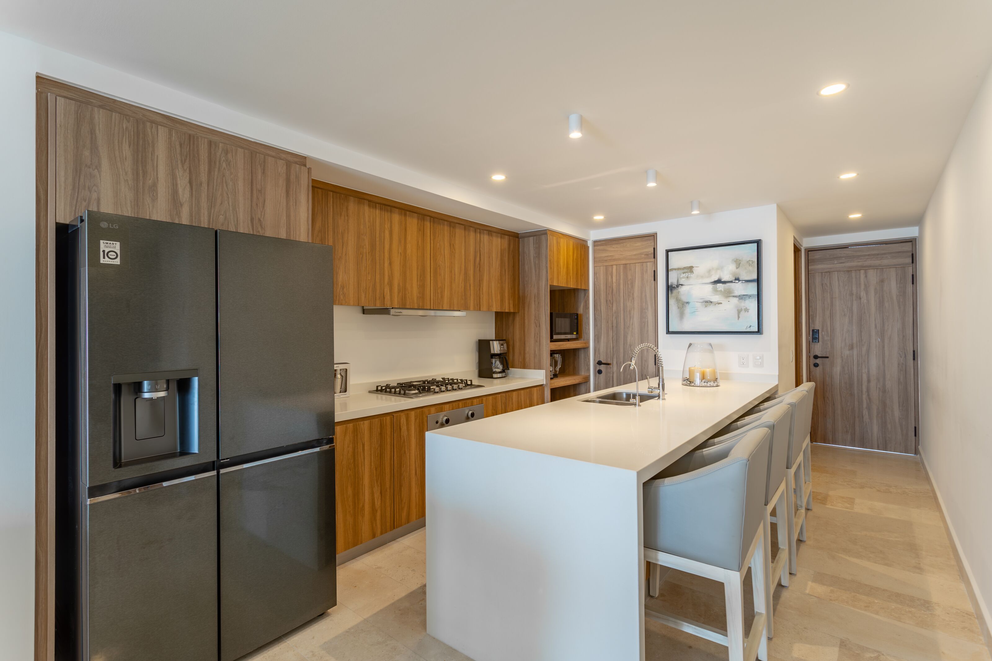 A modern kitchen with a built-in refrigerator, a gas stove, and wooden cabinetry.