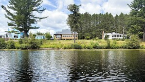 A calm lake with houses in the background.