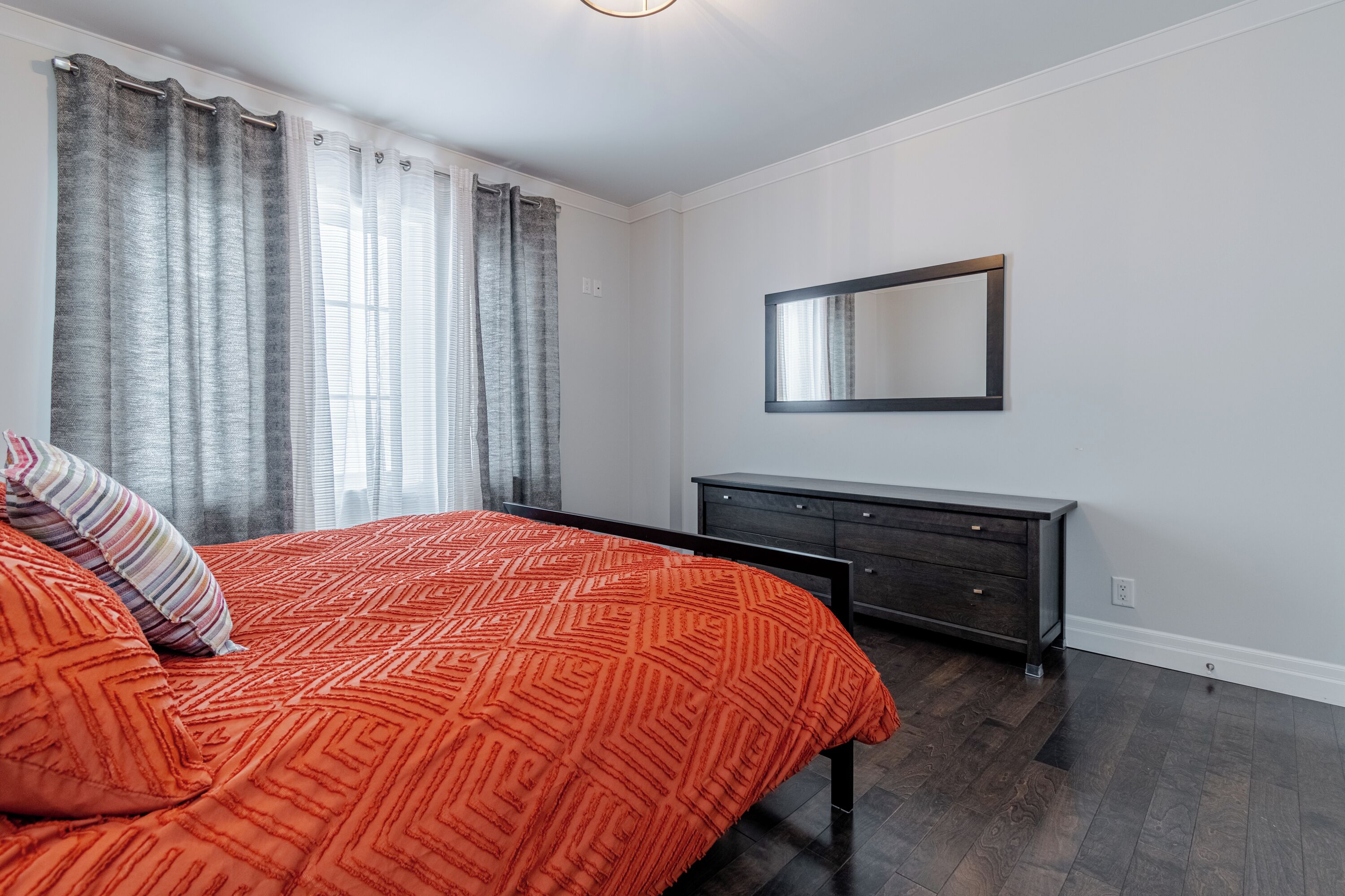 Ein Schlafzimmer mit einem Bett, einem Schminktisch und einem Spiegel an der Wand.
