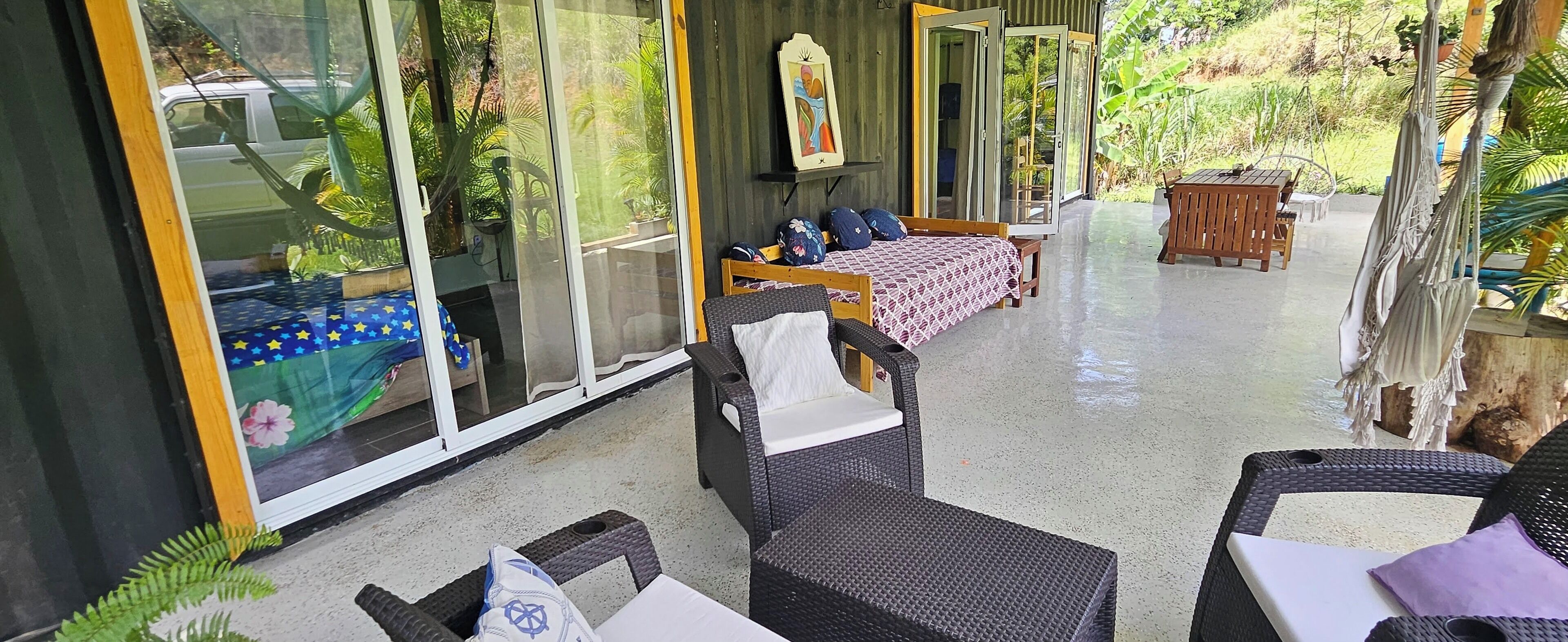Une pièce comprenant un lit, une chaise, une table et une fenêtre donnant sur un paysage verdoyant.