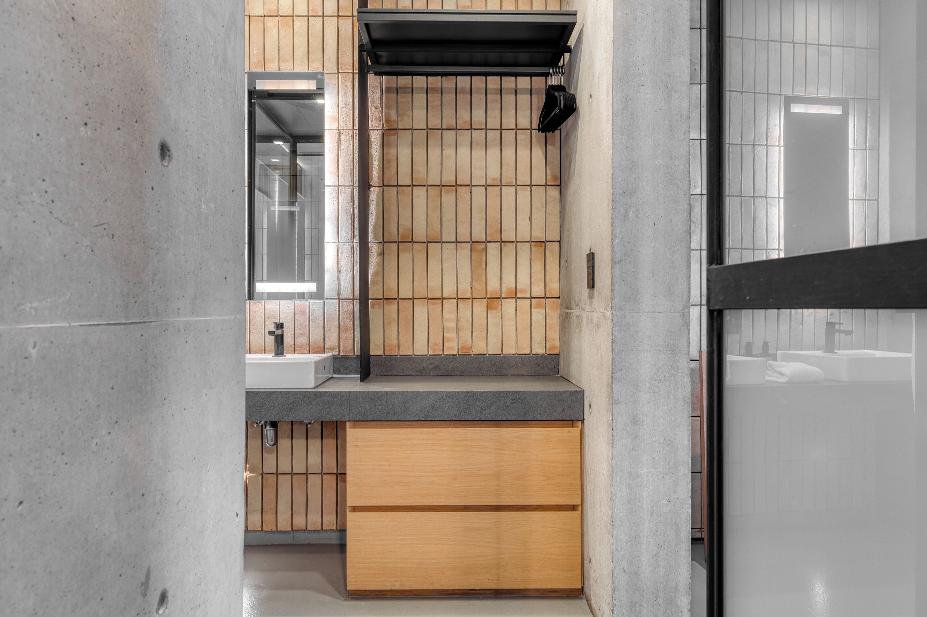 Une salle de bain moderne avec un meuble-lavabo en bois, un évier et un miroir.