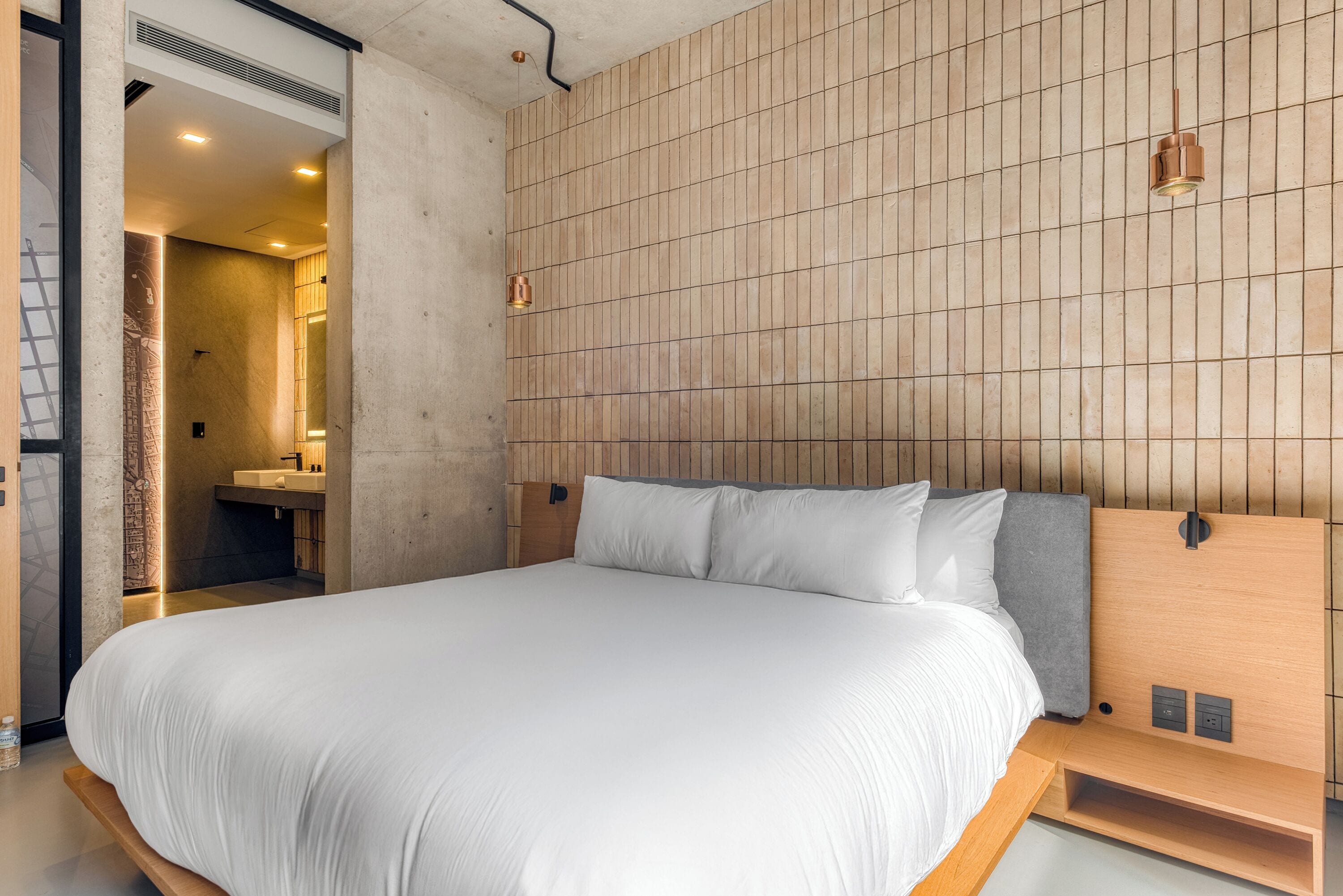 A modern bedroom with a large bed, wooden headboard, and a built-in nightstand.
