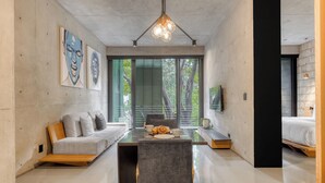 Un interior moderno con zona de comedor, sofá y obras de arte en las paredes.