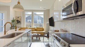 Eine moderne Küche mit Backofen, Mikrowelle und einem großen Fenster.