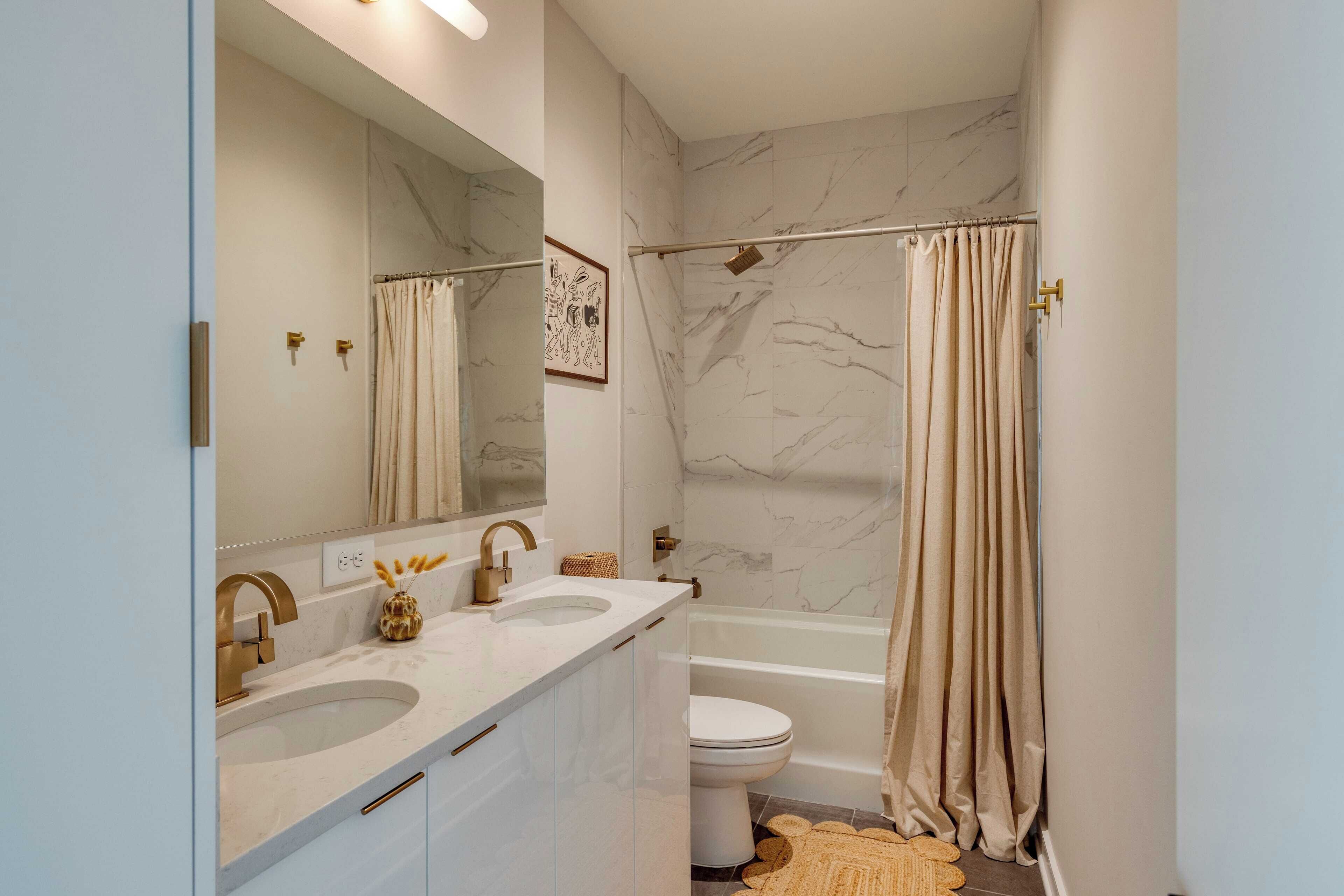 Un baño con dos lavamanos, un inodoro y una bañera.