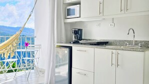 Ein Balkon mit einer Hängematte und einem Tisch mit Blumen in einer Vase.