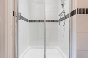 Regadera, secadora de cabello, toallas, papel de baño 