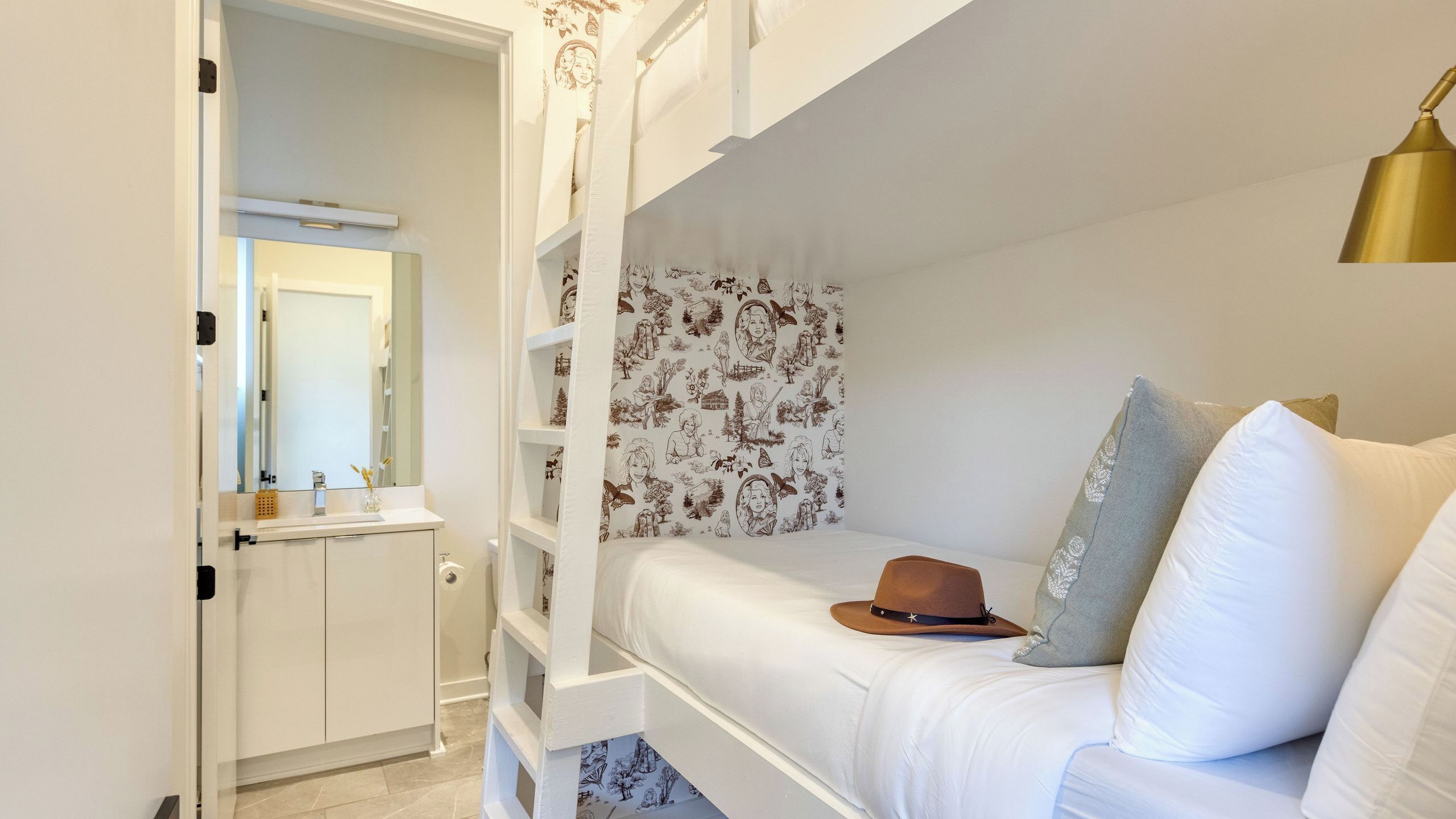 Ein Stockbett mit Kopfteil, ein Nachttisch mit Spiegel und eine Wand mit Muster.