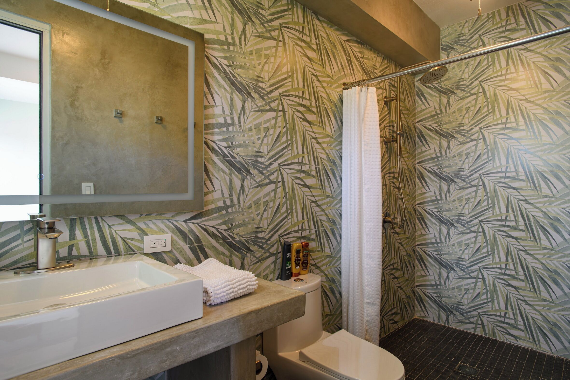 Un bagno con una vasca da bagno ampia, un water e uno spazio doccia.