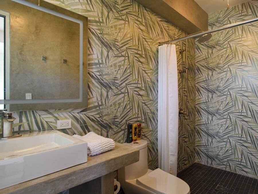 Un bagno con una vasca da bagno ampia, un water e uno spazio doccia.