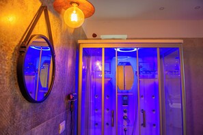 Een aparte badkuip en douche, een bubbelbad, een hydromassagedouche