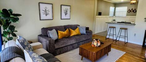 A living room with a sofa, a coffee table, and a ceiling fan.