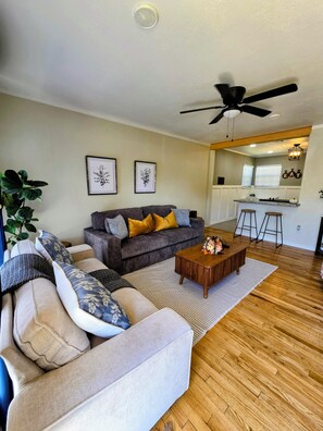A living room with a sofa, a coffee table, and a ceiling fan. - Charming 2-bedroom house in Lubbock TX,  Walking Distance from Texas Tech (Lubbock)