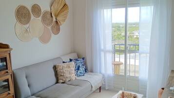 Apartamento premium, acesso à piscina, vista para a praia | Área de estar | Smart TV 32 polegadas com canais digitais, Netflix, filmes pagos