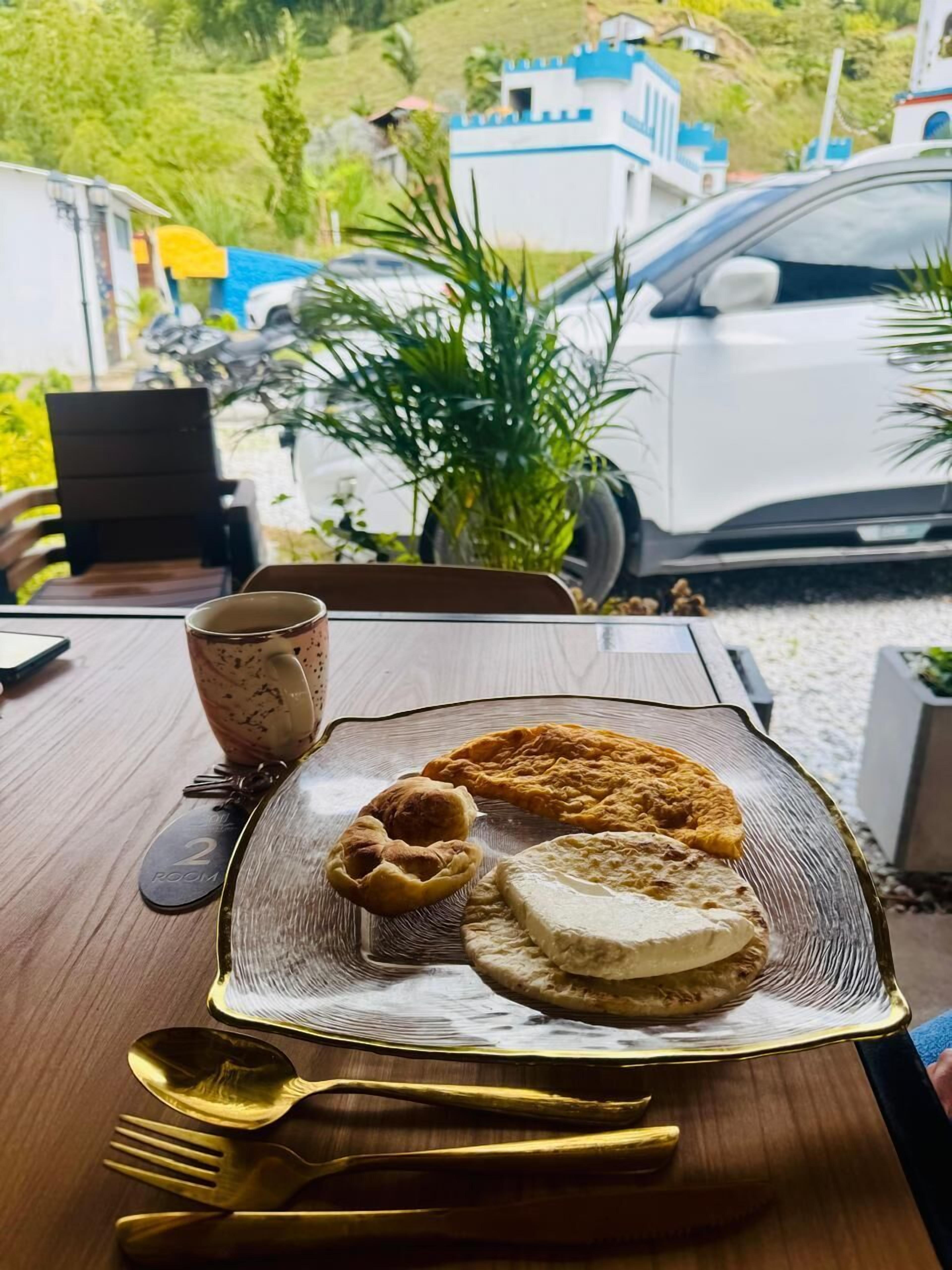 A table with a plate of food, a glass, and a spoon.