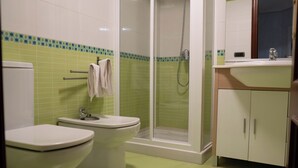 A bathroom with two toilets, a shower, and a sink with a mirror. - Centrally located apartment in Vigo 5 minutes from Puerta del Sol (Vigo)
