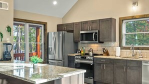 Eine moderne Küche mit Granit-Arbeitsplatten, Edelstahlgeräten und dunklen Holzschränken.