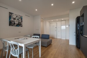 Eine moderne Küche mit weißen Schränken und einem schwarzen Kühlschrank.
