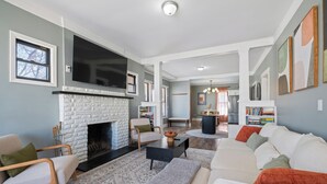 A living room with a fireplace, a sofa, a coffee table, and a bookshelf.