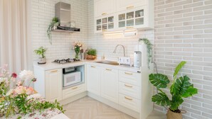 Una cucina moderna con mobili bianchi, forno integrato e cappa aspirante in acciaio inossidabile.
