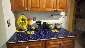 A kitchen with wooden cabinets, a blue tiled countertop, and various kitchen appliances. - Charming 2-bedroom townhome in welcoming Heredia with WiFi, AC in walkable town (Heredia)