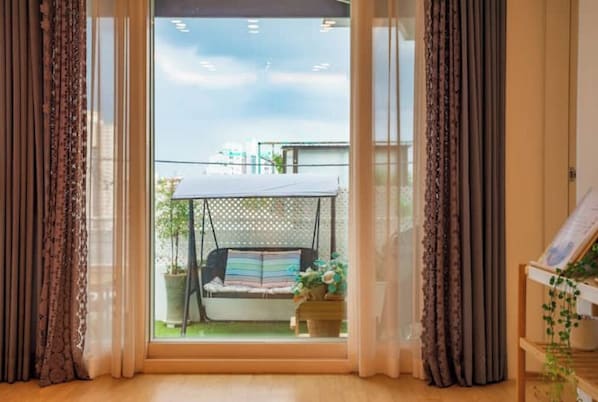 A room with a large window, a swing chair outside, and curtains on either side. - Haiyan House, Private Seoul Stay with Courtyard (Seoul)