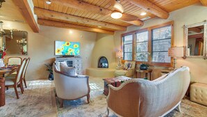 A cozy living room with a fireplace, comfortable seating, and a large painting. - Luxury Condo in the Heart of Santa Fe: Corazon 32 (Santa Fe)