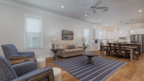 A spacious living room with a sofa, coffee table, and dining area. - 3BR/3BA perfect location in Ocean Springs-walk to downtown-Moondance on Magnolia (Ocean Springs)