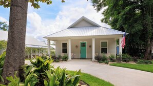 A single-story house with a green door, a white roof, and an American flag. - 3BR/3BA perfect location in Ocean Springs-walk to downtown-Moondance on Magnolia (Ocean Springs)
