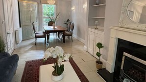 Un coin repas avec une table et des chaises, une cheminée et une plante en pot.