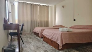 A hotel room with two beds, a desk, and a chair. - Hotel la fortuna (Tuxpan)