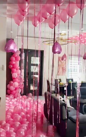 A room with pink balloons and streamers, a black door, and a desk with a computer. - The Onyx Beach Villa by MTJ Properties (Plantation Village)