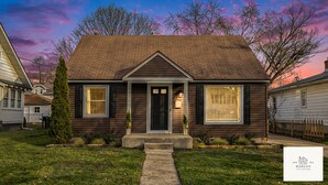 A two-story house with a front porch, a brick chimney, and a number '706' on the door. - The Harlan City Cottage - Extended Stay Welcome (Grand Rapids)