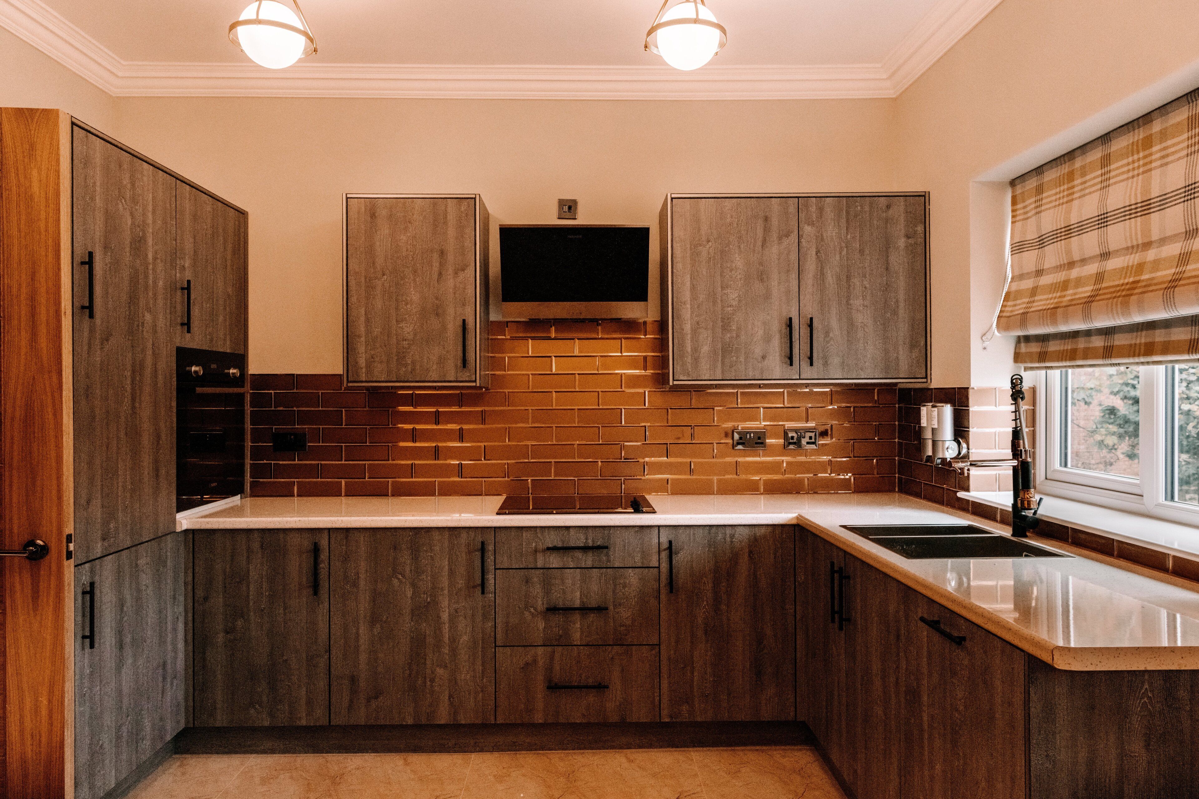 Una cocina con armarios de madera, salpicadero de ladrillo y horno empotrado.