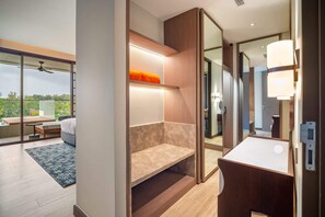Habitació d'hotel moderna amb un balcó, un mirall gran, una taula de nit i una banca integrada.