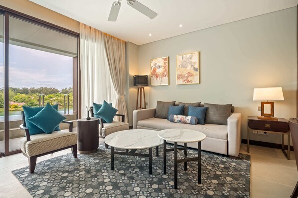 Una sala de estar moderna con un sofá, sillones, una mesa de centro y un televisor.