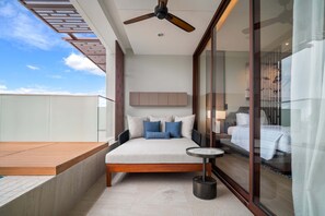 Une chambre à coucher moderne avec un lit, une petite table ronde et un ventilateur de plafond.