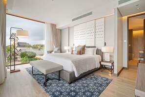 Ein modernes Hotelzimmer mit einem großen Bett, Nachttischen, einer Bank und Blick ins Freie.