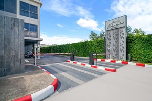 A gated entrance to a hotel with a modern building and a sign reading "Laguna Lakeside Residence".