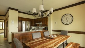 Una cocina con armarios de madera, una isla central y una mesa de comedor con sillas.