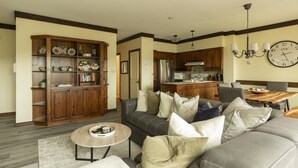 Una sala de estar con un sofá, una mesa de centro y un mueble de madera con objetos decorativos.