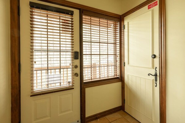 A door with a window, a doorbell, and a sign indicating a water valve.