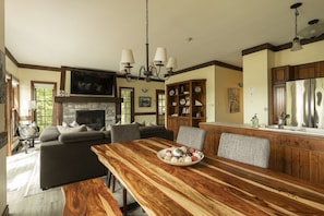 Ein geräumiges Wohnzimmer mit Kamin, ein Essbereich mit Holztisch und eine Küche mit Holzschränken.