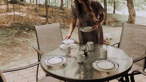 An outdoor dining area with a round table and chairs, surrounded by trees. - Just steps from Tremblant • Free shuttle (Mont-Tremblant)