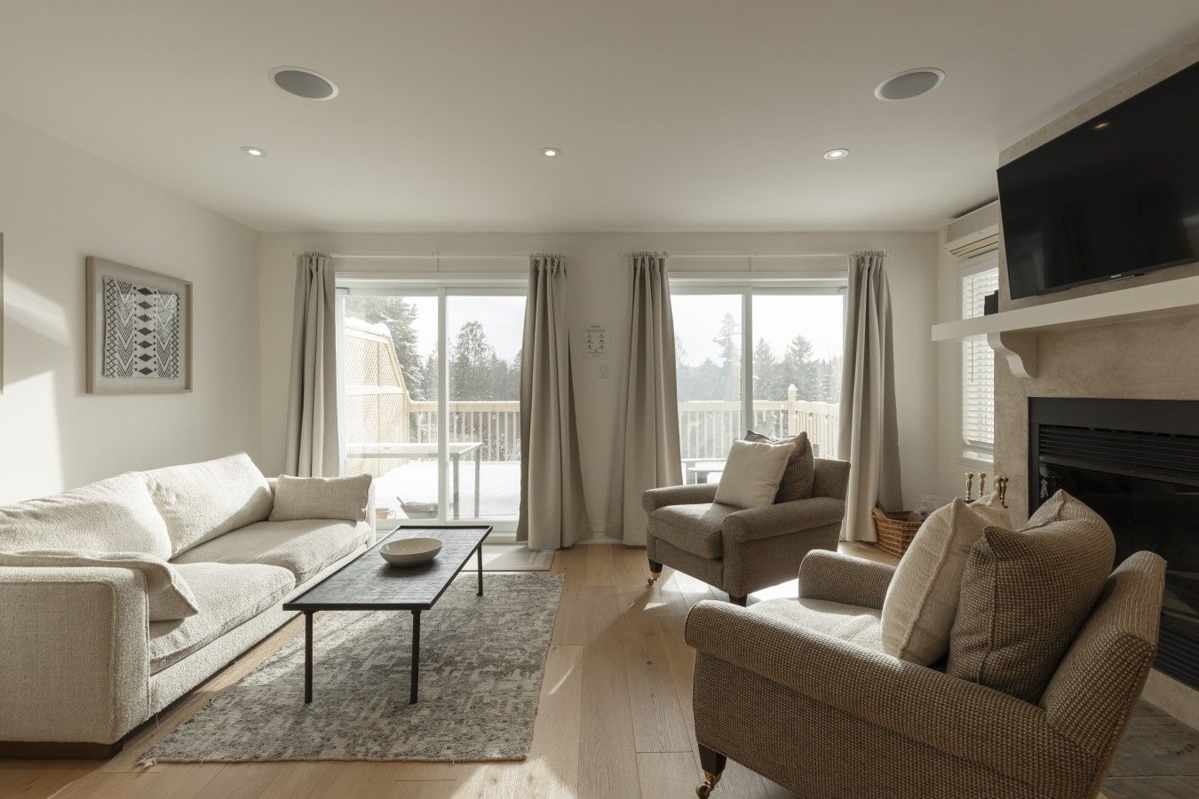 A living room with a sofa, armchair, and a fireplace.