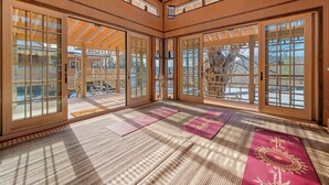 A traditional Japanese room with tatami flooring, sliding doors, and a view of the outdoors.