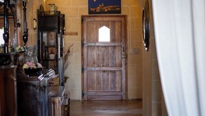 A hallway with a wooden door, a painting of a night scene, and a tiled floor. - il figolla (Xaghra)