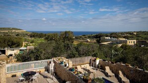 A rooftop terrace with outdoor seating, a pool, and a view of the sea and surrounding landscape. - il figolla (Xaghra)